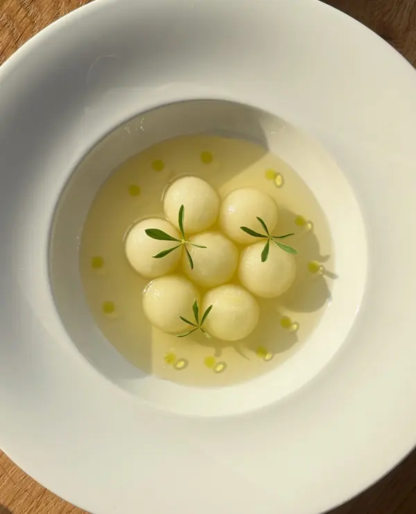 Gele honingmeloen met tomatenconsommé en basilicumolie